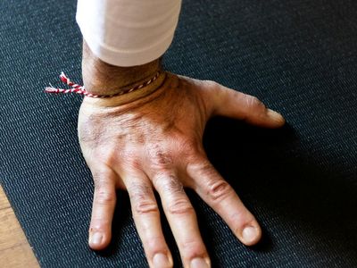 Close-up of balanced yoga posture on a black mat